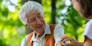 Elderly man smiles while speaking with a legal professional about estate planning and real estate
